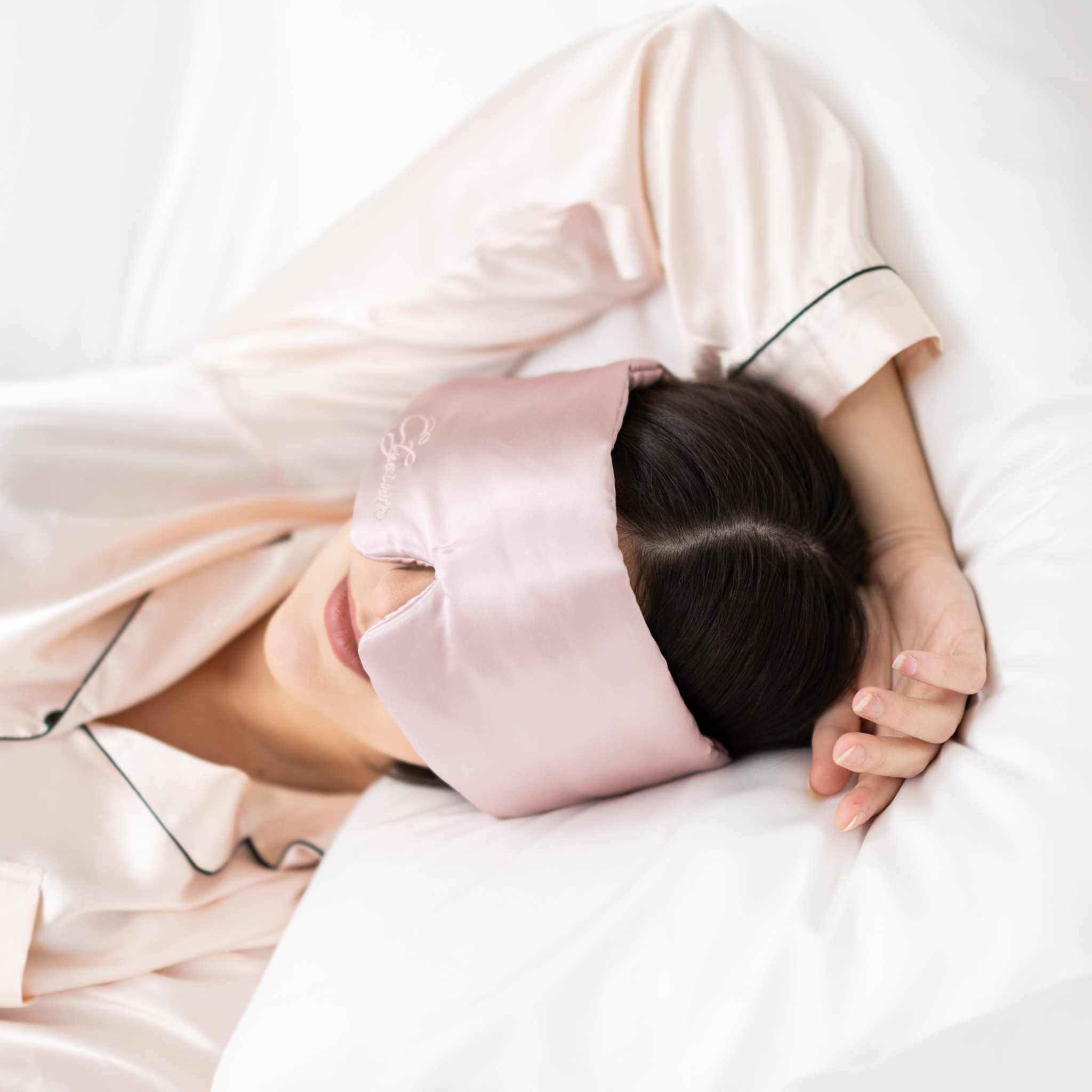 Luxury silk sleep mask with adjustable wraparound design in light pink, perfect for travel and deep, restful sleep.
