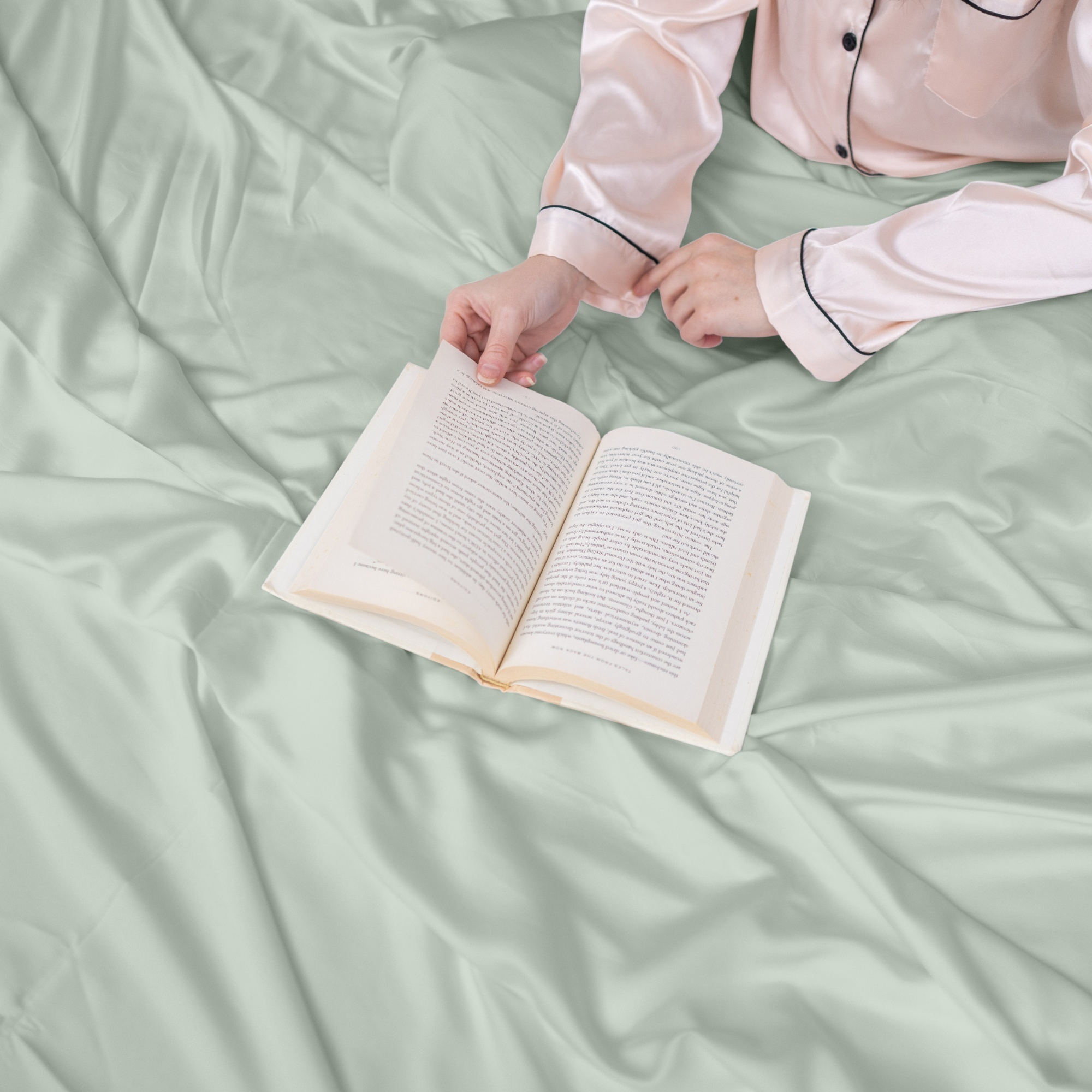 Seaglass green bamboo sheets with person reading book, showcasing ultra-soft and breathable fabric.