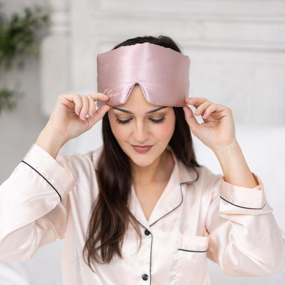Young woman wearing pink silk sleep mask