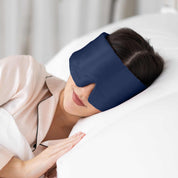 Young woman side sleeping in bed with Elysium Silk Eye Mask in Navy 