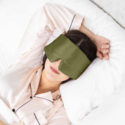 Woman sleeping with Elysium Silk Sleep Mask in Avocado