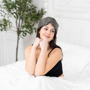 Young woman relaxing with Elysium Silk Sleep Blindfold in Metal Grey