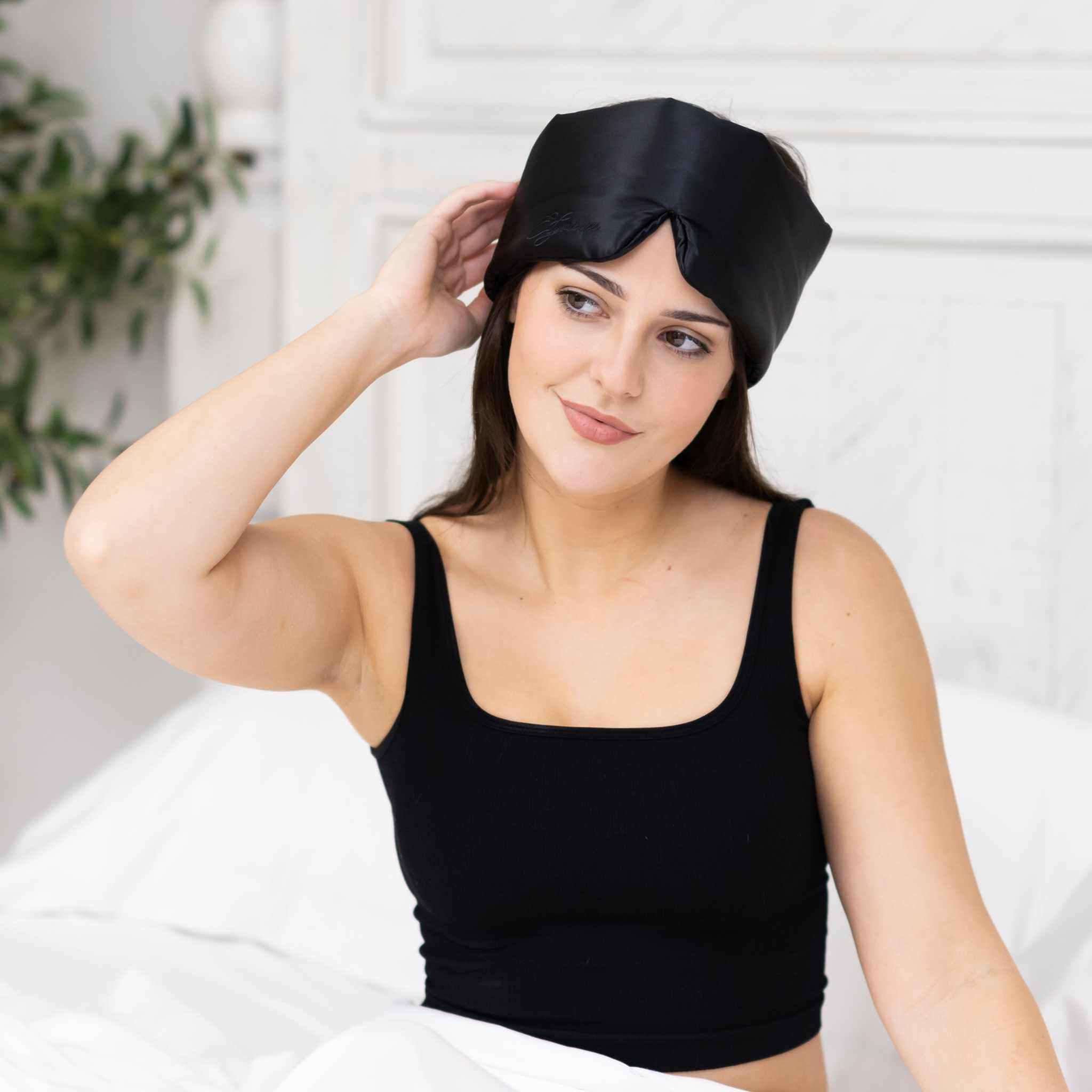 Young woman relaxing with Elysium Silk Eye Mask for sleeping in Black