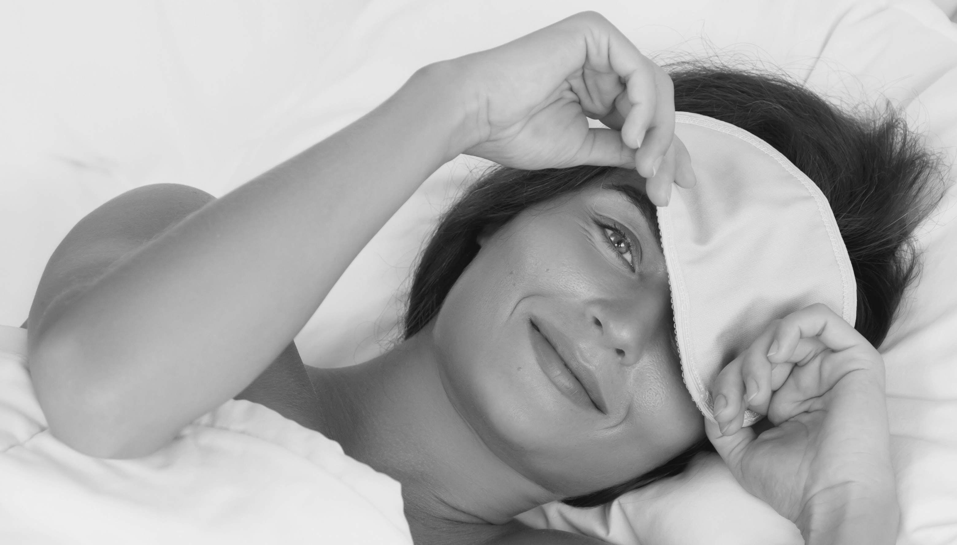 young woman waking up in organic bamboo sheets